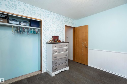 This interior space features light blue walls, one of which is adorned with a delicate leaf pattern wallpaper - 4420 56 Avenue, Barrhead, AB - Indoor