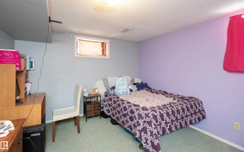This room features a window, light green carpet, and walls painted in two tones - 4420 56 Avenue, Barrhead, AB - Indoor Photo Showing Bedroom