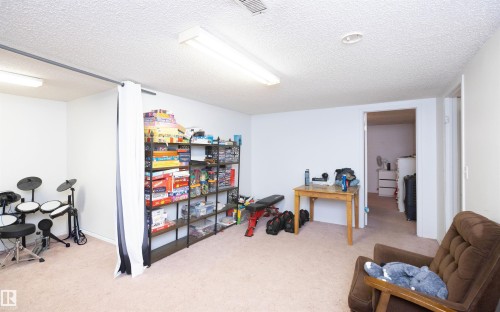 The room features light-colored carpeted flooring and white walls, creating a bright atmosphere - 4420 56 Avenue, Barrhead, AB - Indoor