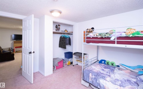 This room features light-colored walls, a closet with a hanging rod, and a bunk bed - 4420 56 Avenue, Barrhead, AB - Indoor Photo Showing Bedroom