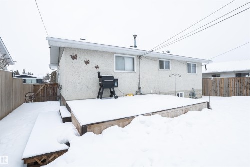 The property features a rear exterior with a stucco finish and a wooden deck - 4420 56 Avenue, Barrhead, AB - Outdoor With Exterior