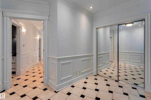 This room features white walls with wainscoting and crown molding, tile flooring with a black and light pattern, and recessed lighting - 102 11826 100, Edmonton, AB - Indoor Photo Showing Other Room