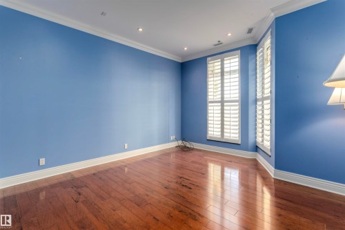 This room offers hardwood flooring, recessed lighting, and white plantation shutters on the windows - 102 11826 100, Edmonton, AB - Indoor Photo Showing Other Room