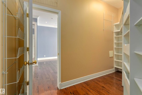 The property features hardwood floors, a built-in shelving unit, and a built-in wire rack storage system - 102 11826 100, Edmonton, AB - Indoor Photo Showing Other Room