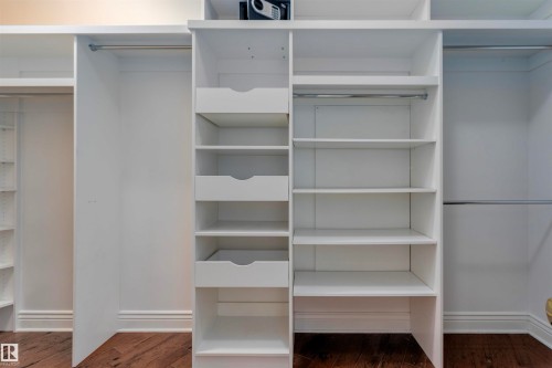 Custom closet system featuring white shelving, integrated drawers, and hanging rods - 102 11826 100, Edmonton, AB - Indoor With Storage