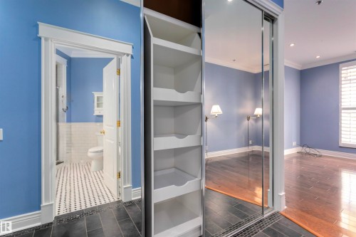 The property features built-in shelving, mirrored closet doors, and hardwood flooring - 102 11826 100, Edmonton, AB -  Photo Showing Other Room