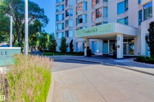 The property features a modern facade with large windows and a covered entrance - 102 11826 100, Edmonton, AB - Outdoor With Facade