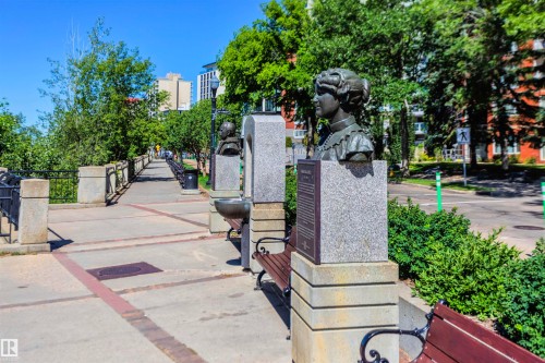 The property is located in a community featuring a paved walking path, mature trees, and landscaping - 102 11826 100, Edmonton, AB - Outdoor