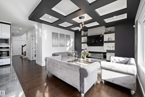 The living area features hardwood floors and a coffered ceiling with recessed lighting - 6303 169 Avenue, Edmonton, AB - Indoor Photo Showing Living Room