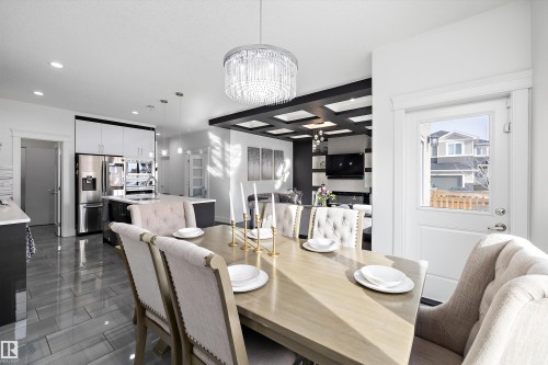 Open concept dining area featuring a chandelier, a table, and upholstered chairs - 6303 169 Avenue, Edmonton, AB - Indoor Photo Showing Dining Room