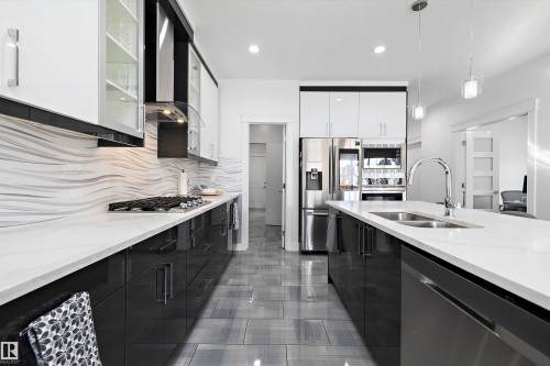 The kitchen features white countertops, a dual-basin sink, and stainless steel appliances - 6303 169 Avenue, Edmonton, AB - Indoor Photo Showing Kitchen With Stainless Steel Kitchen With Double Sink With Upgraded Kitchen