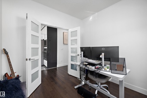 This versatile room features rich dark wood flooring and white walls, offering a bright and functional space - 6303 169 Avenue, Edmonton, AB - Indoor Photo Showing Office