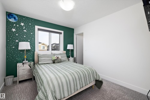 The property features a bedroom with a window, a partial accent wall, and carpet flooring - 6303 169 Avenue, Edmonton, AB - Indoor Photo Showing Bedroom