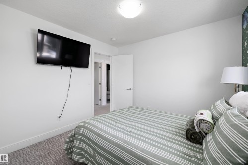 This room features light-colored walls and a wall-mounted television - 6303 169 Avenue, Edmonton, AB - Indoor Photo Showing Bedroom