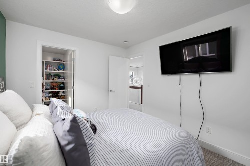 Bedroom featuring a built-in closet with shelving and a mounted light fixture - 6303 169 Avenue, Edmonton, AB - Indoor Photo Showing Bedroom