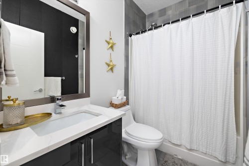 The bathroom features a modern vanity with a white countertop and a rectangular undermount sink, complemented by a chrome faucet - 6303 169 Avenue, Edmonton, AB - Indoor Photo Showing Bathroom