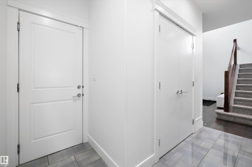 Entryway featuring light gray tiled flooring, white walls, and white doors with silver hardware - 6303 169 Avenue, Edmonton, AB - Indoor Photo Showing Other Room