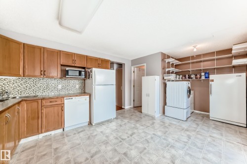 Kitchen with white appliances, brown cabinetry, and decorative backsplash - 11609 125 Street, Edmonton, AB - Indoor