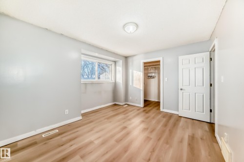 Unfurnished bedroom with a walk in closet and light wood finished floors - 11609 125 Street, Edmonton, AB - Indoor Photo Showing Other Room