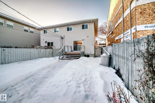 Snow covered rear of property featuring a fenced backyard and a wooden deck - 11609 125 Street, Edmonton, AB - Outdoor