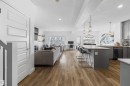 The property features an open-concept layout with hardwood floors throughout the main living areas, a kitchen island with seating, pendant lighting, and recessed lighting - 4917 Charles Point(E), Edmonton, AB  - Indoor 