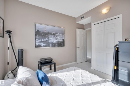 This room features neutral-toned walls, a white bi-fold closet, and a white door with a dark handle - 106 3040 Spence Wynd, Edmonton, AB - Indoor Photo Showing Bedroom