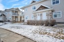 The property features a light-colored exterior with stone accents and multiple windows - 106 3040 Spence Wynd, Edmonton, AB  - Outdoor With Balcony With Facade 