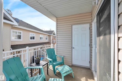 The property features a private balcony with a white railing, providing an outdoor space with a view of other properties - 106 3040 Spence Wynd, Edmonton, AB - Outdoor With Deck Patio Veranda With Exterior