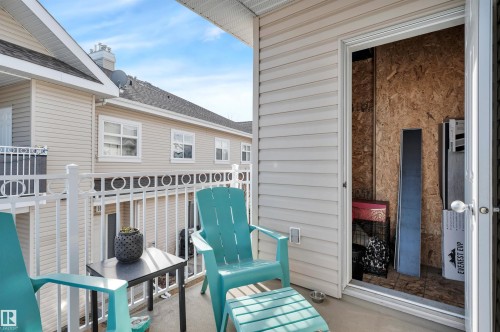The property features an outdoor patio with a white railing, providing a relaxing space - 106 3040 Spence Wynd, Edmonton, AB - Outdoor With Deck Patio Veranda With Exterior