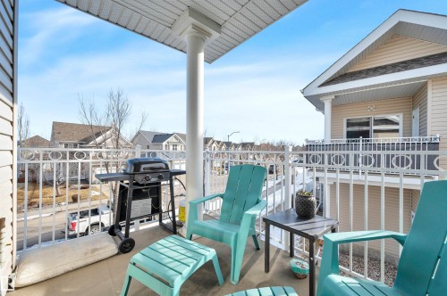 The property features a concrete balcony with a white railing, providing views of the surrounding neighborhood - 106 3040 Spence Wynd, Edmonton, AB - Outdoor With Deck Patio Veranda With Exterior