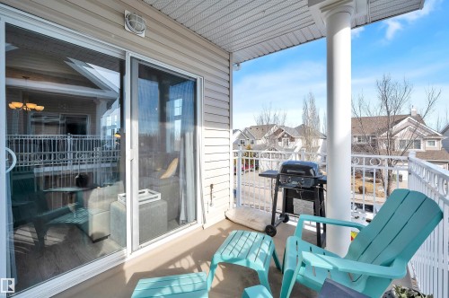 The property features a balcony with white railings, offering views of the surrounding neighborhood - 106 3040 Spence Wynd, Edmonton, AB - Outdoor With Balcony With Deck Patio Veranda With Exterior