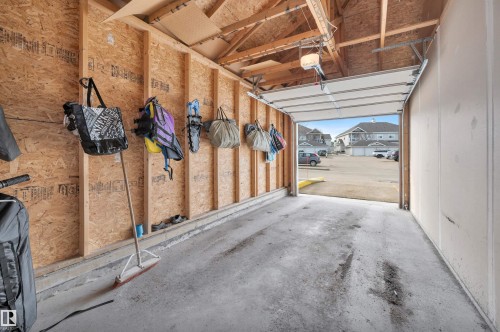 The property features a garage with exposed wooden beams and a concrete floor - 106 3040 Spence Wynd, Edmonton, AB - Indoor Photo Showing Garage