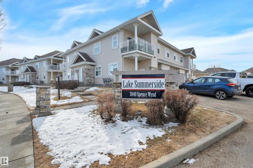 The property features a multi-story building with light-colored siding and dormer windows - 106 3040 Spence Wynd, Edmonton, AB - Outdoor With Balcony With Facade