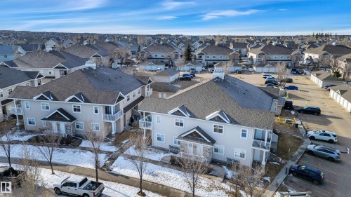 The property features a multi-level design with balconies and a stone facade entrance - 106 3040 Spence Wynd, Edmonton, AB - Outdoor