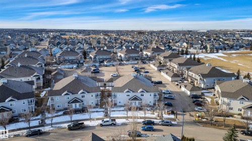 An aerial view showcasing a neighborhood with residential properties, featuring a clear sky overhead - 106 3040 Spence Wynd, Edmonton, AB - Outdoor With View