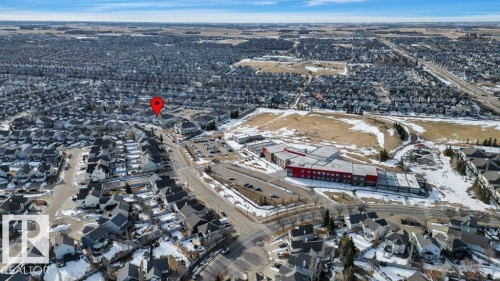 Aerial view of the surrounding residential area and commercial properties, featuring a road network and open land - 106 3040 Spence Wynd, Edmonton, AB - Outdoor With View