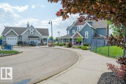 The property features a blue exterior with white trim and a covered porch - 106 3040 Spence Wynd, Edmonton, AB - Outdoor With Facade