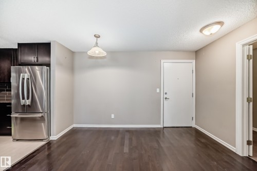 This inviting living space features dark wood flooring, light-colored walls, and overhead lighting fixtures - 208 2204 44 Ave, Edmonton, AB - Indoor
