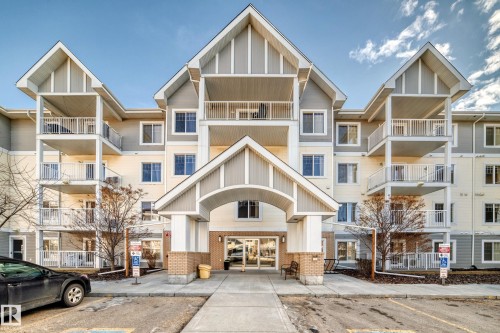 The property features a multi-story building with a light-colored exterior and prominent gabled rooflines - 208 2204 44 Ave, Edmonton, AB - Outdoor With Balcony With Facade