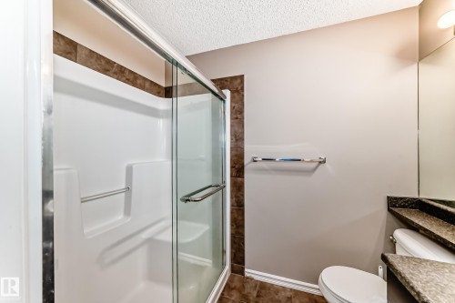This bathroom features a shower with a clear glass enclosure and a white shower base - 208 2204 44 Ave, Edmonton, AB - Indoor Photo Showing Bathroom