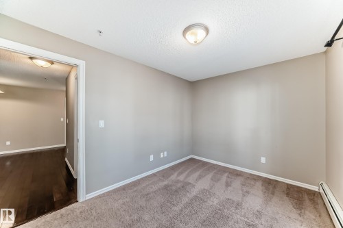 This room features a neutral color palette, with light brown carpeting, light gray painted walls, and white trim - 208 2204 44 Ave, Edmonton, AB - Indoor Photo Showing Other Room