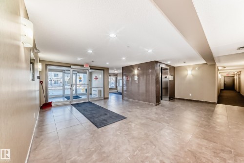 Property lobby featuring tile flooring, recessed lighting, and a stainless steel elevator - 208 2204 44 Ave, Edmonton, AB - Indoor Photo Showing Other Room