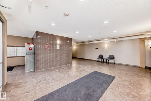 The property features a reception area with large format tile flooring and recessed lighting - 208 2204 44 Ave, Edmonton, AB - Indoor