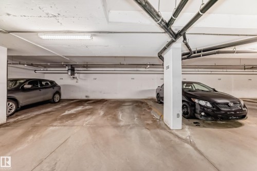 Designated parking space within a well-lit underground parking facility - 208 2204 44 Ave, Edmonton, AB - Indoor Photo Showing Garage