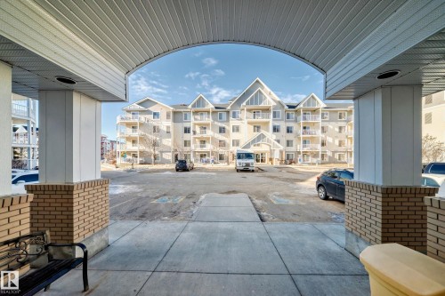 The property features a multi-story building with light-colored siding and several balconies - 208 2204 44 Ave, Edmonton, AB - Outdoor With Balcony