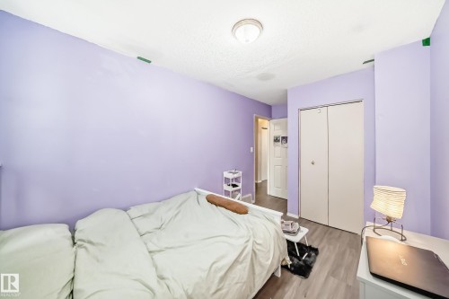 This room features light purple walls, a ceiling-mounted light fixture, and light-colored flooring - 11393 22 Avenue, Edmonton, AB - Indoor Photo Showing Bedroom