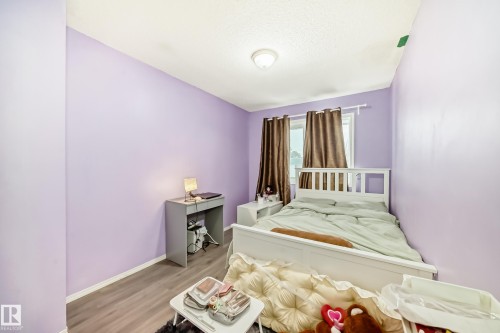 This room features light purple walls, a window with brown curtains, and a white bed frame - 11393 22 Avenue, Edmonton, AB - Indoor