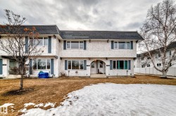 The property features a multi-level structure with a grey roof and white exterior, complemented by blue window shutters - 