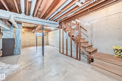 The property features an unfinished basement with exposed wooden joists and concrete walls, providing a blank canvas for customization - 11393 22 Avenue, Edmonton, AB - Indoor Photo Showing Basement
