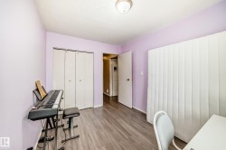 This room features light purple walls, wood-look flooring, and a ceiling light fixture - 